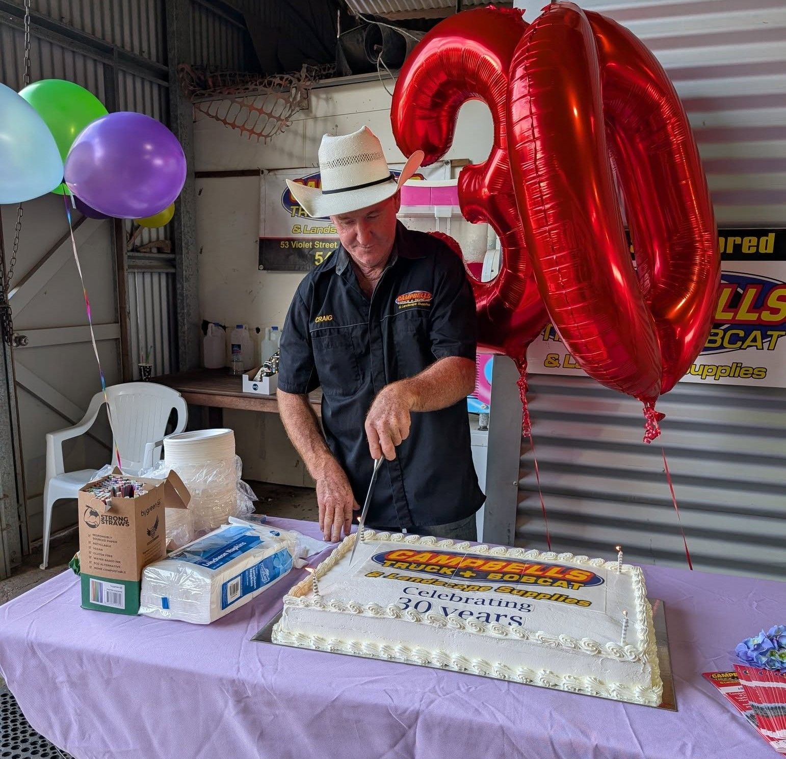 A Man is Cutting a Cake — Campbell's Truck and Bobcat and Landscape Supplies In Gympie, WLD