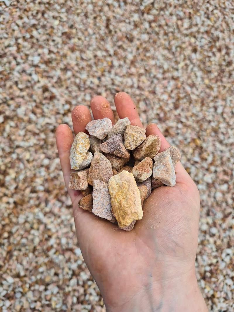A Person Is Holding A Pile Of Rocks In Their Hand — Campbell's Truck and Bobcat and Landscape Supplies In Gympie, QLD
