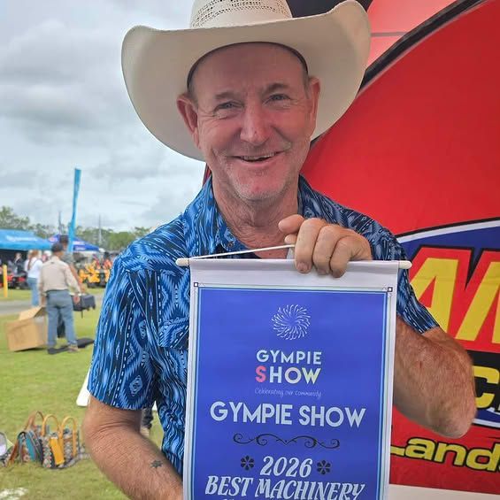 Man in Cowboy Hat Holding a Sign — Campbell's Truck and Bobcat and Landscape Supplies In Gympie, WLD