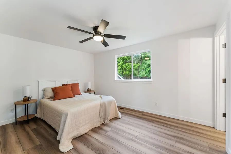 A bedroom with a bed and a ceiling fan.