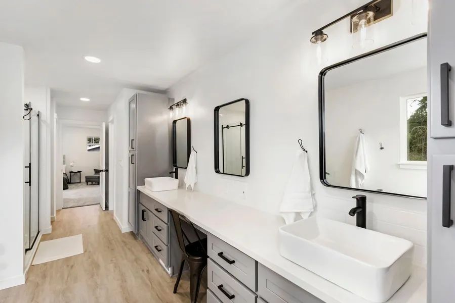 A bathroom with two sinks and two mirrors.
