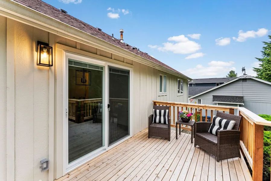 There is a deck with chairs and a table on it.
