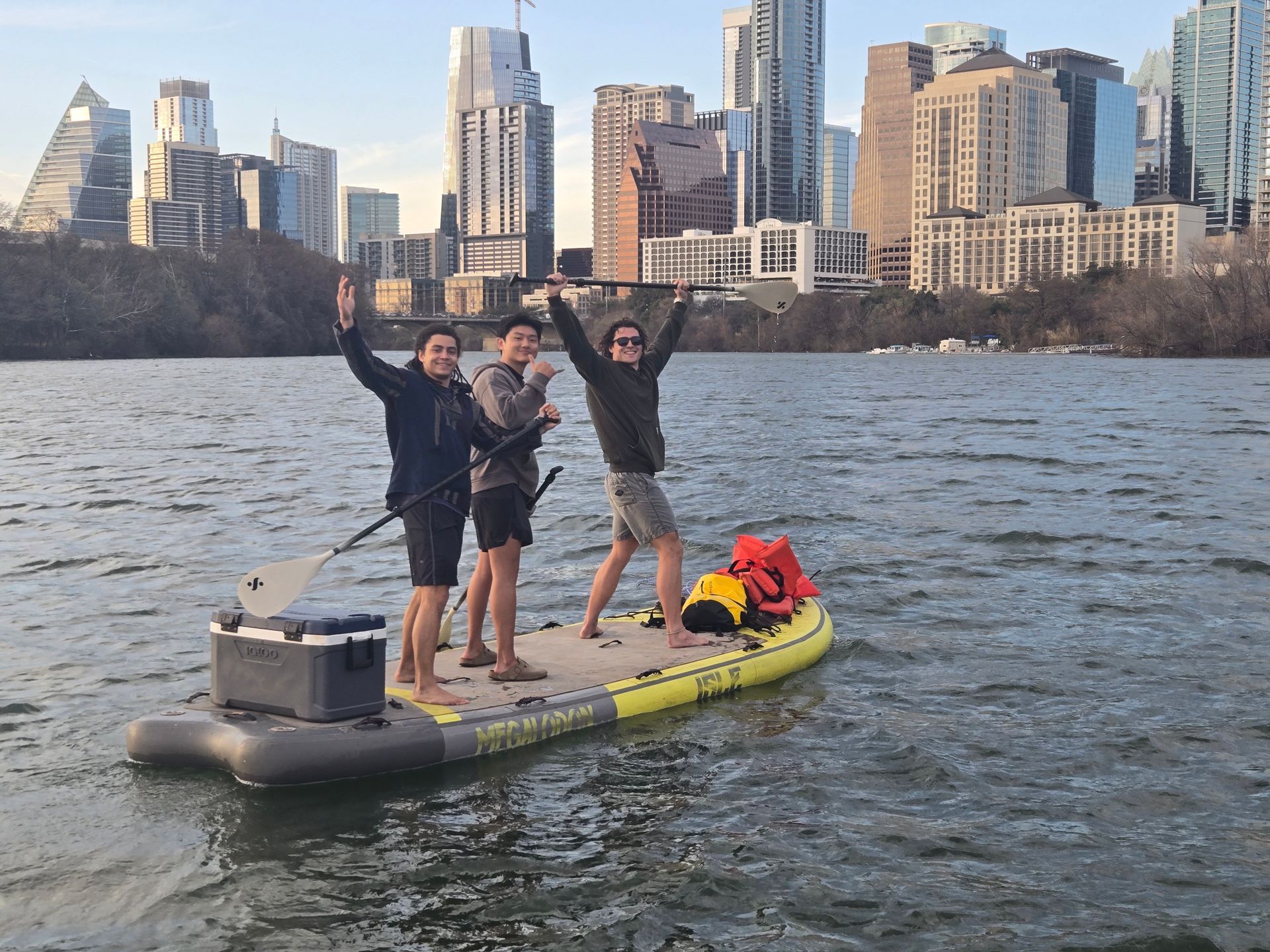 Winter paddleboarders in layered athletic gear and sweatshirts on Lady Bird Lake