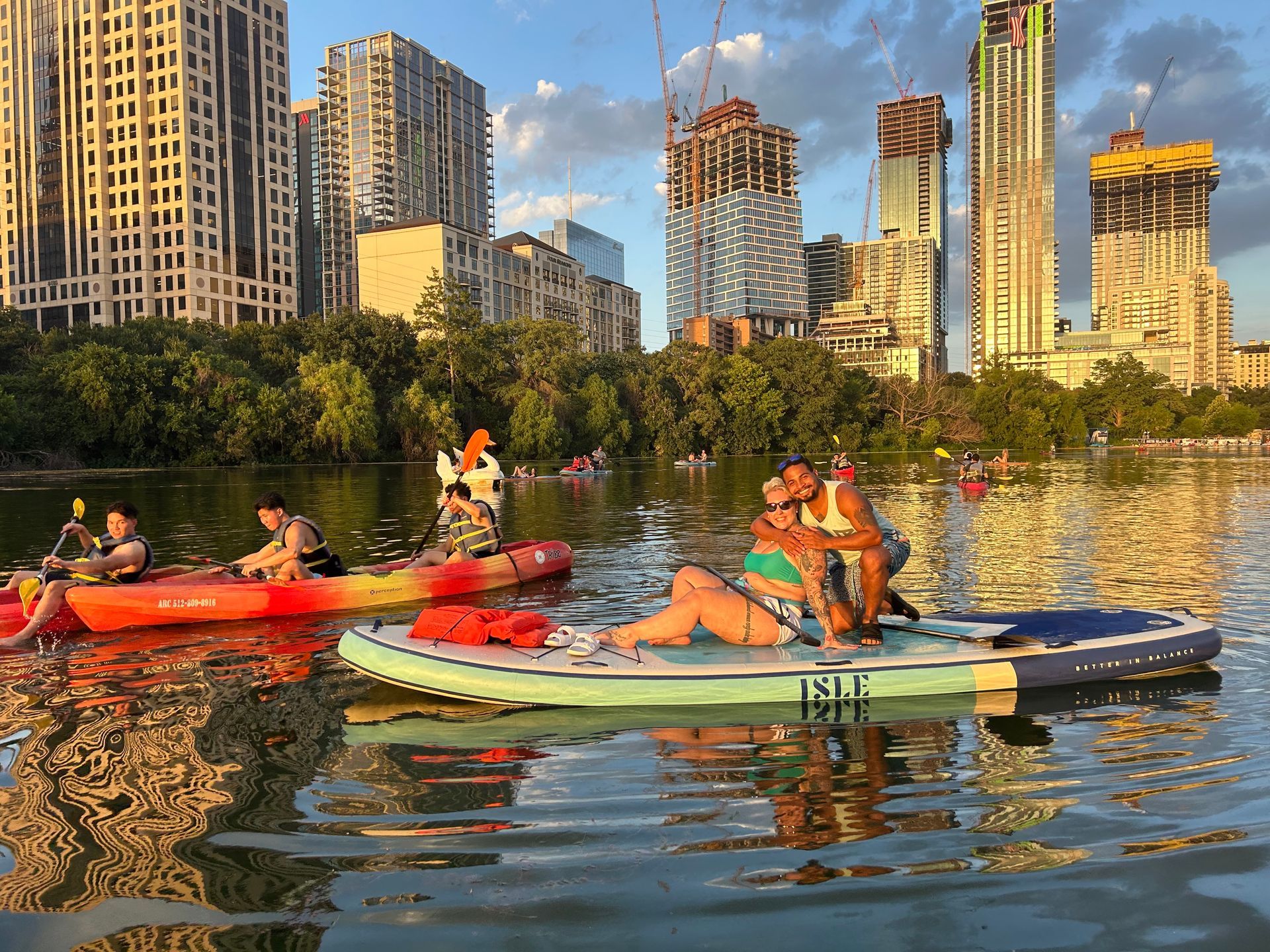 Paddleboarding in Austin on Lady Bird Lake during fall with colorful trees reflecting on the lake
