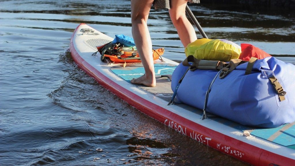 Helpful items for a paddleboard tour, including a dry bag with water and snacks.