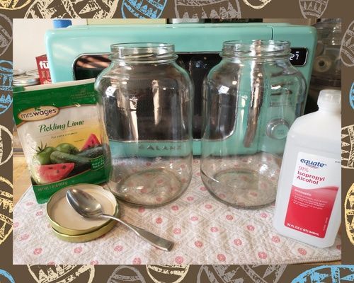 A bottle of alcohol is next to two jars and a spoon