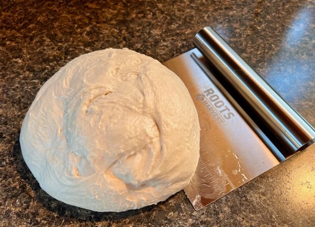 ball of dough and a steel dough scraper