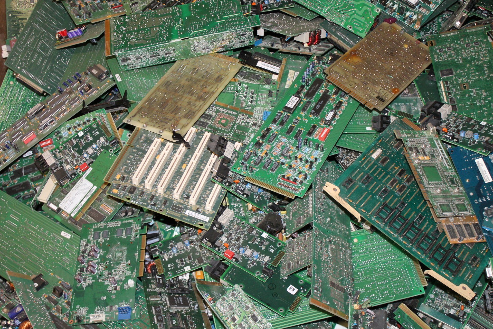 Pile of green printed circuit boards and electronic scrap with copper and metal components