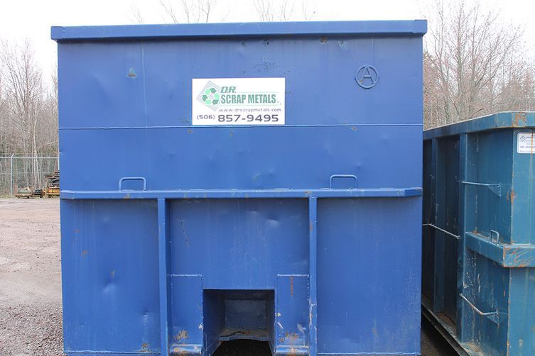 Blue metal dumpster with a white sign, outdoors beside another container