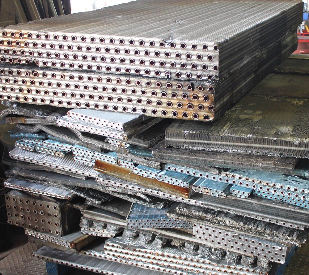Stacks of metal scaffolding planks and frames stored in a warehouse.