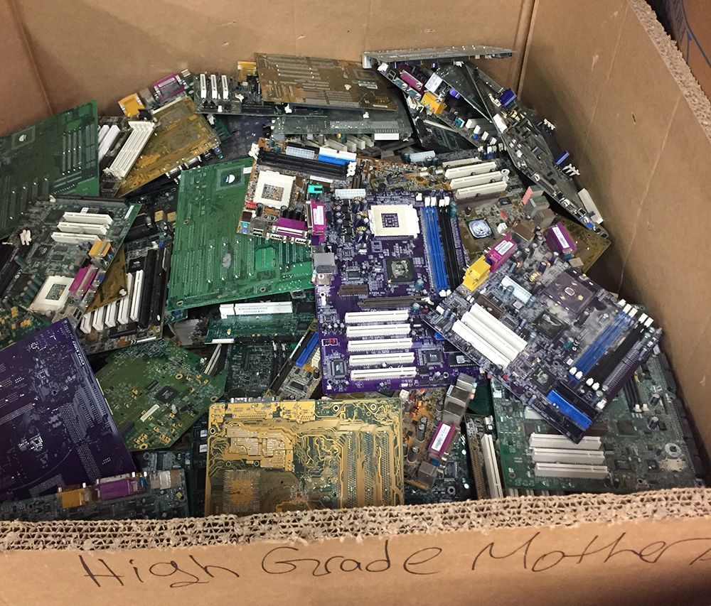 Cardboard box filled with assorted used motherboards and computer circuit boards