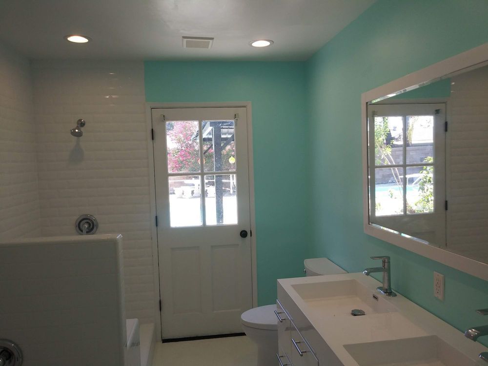 A bathroom with two sinks a toilet and a mirror