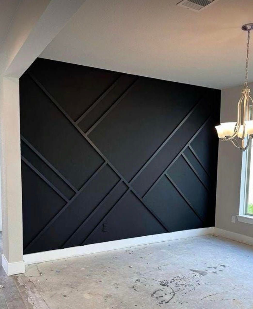 A dining room with a black wall and a chandelier hanging from the ceiling.