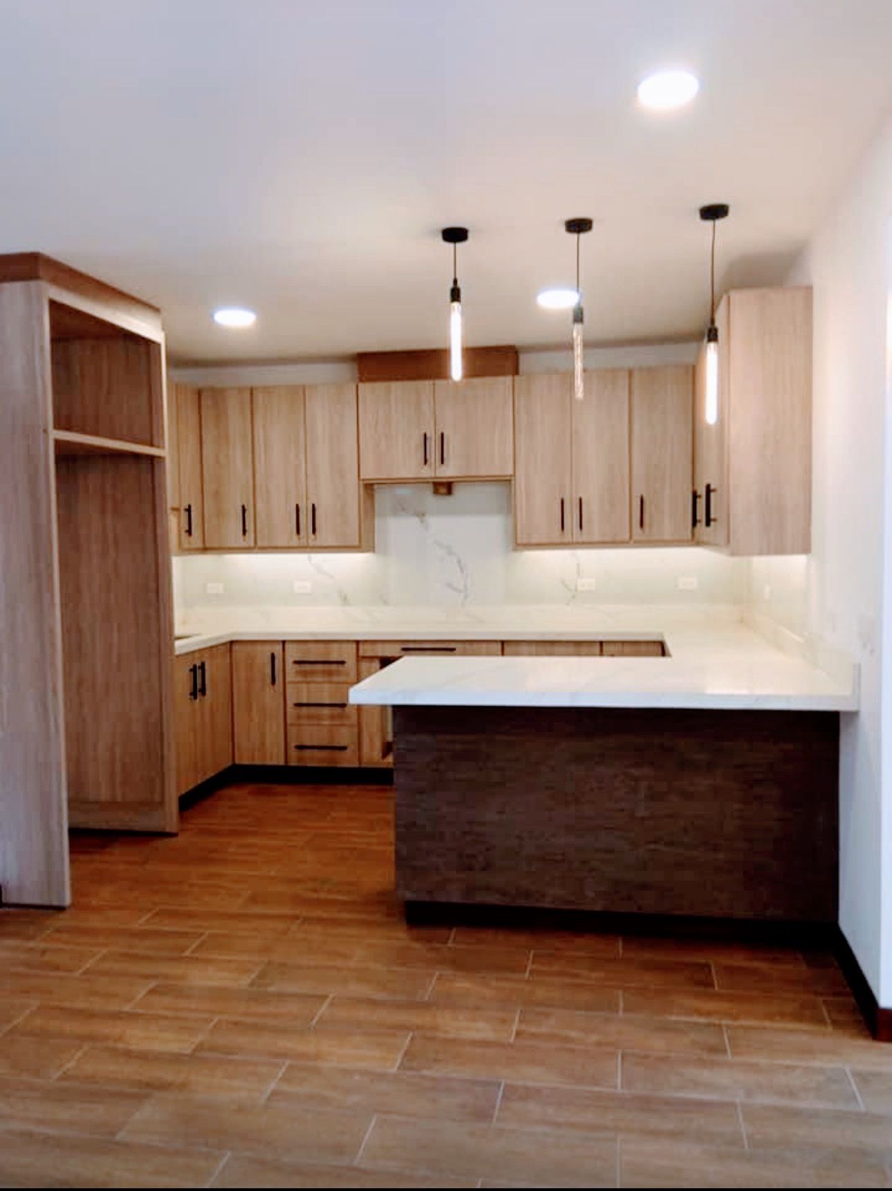 A kitchen with wooden cabinets and a white counter top
