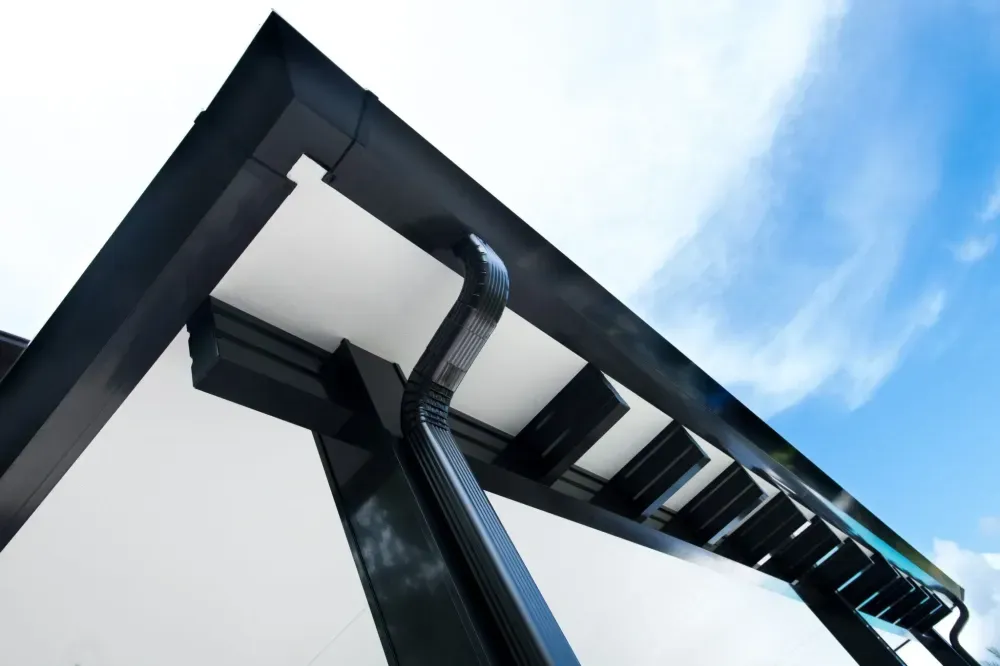 Low-angle view of a modern black-and-white building against a blue sky