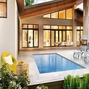Modern home patio with a small blue pool, lounge chairs, and large windows under a sloped roof