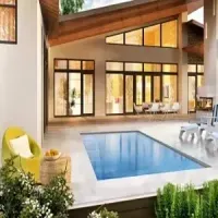 Modern home patio with a small blue pool, lounge chairs, and large windows under a sloped roof