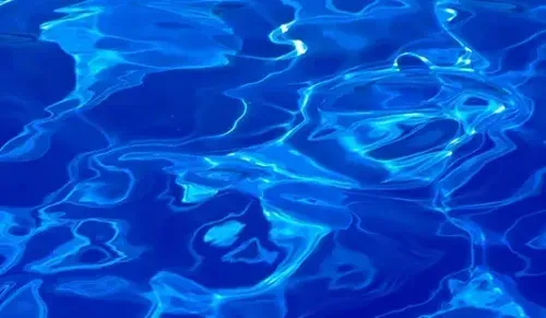 Blue rippling water with bright sunlight reflections