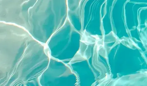 Sunlit turquoise water with shimmering ripples and white reflections