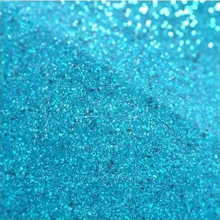 Close-up of shimmering turquoise glitter texture with sparkling light reflections