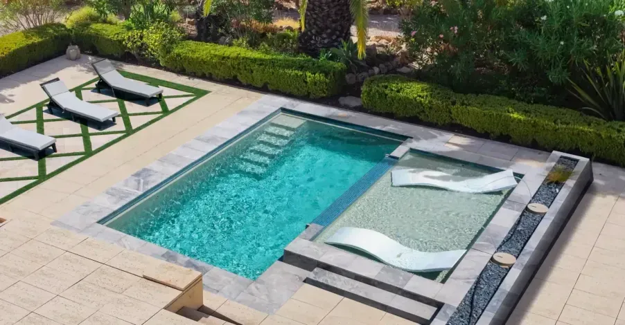 Modern house with a pool, patio seating, and landscaped garden at sunset