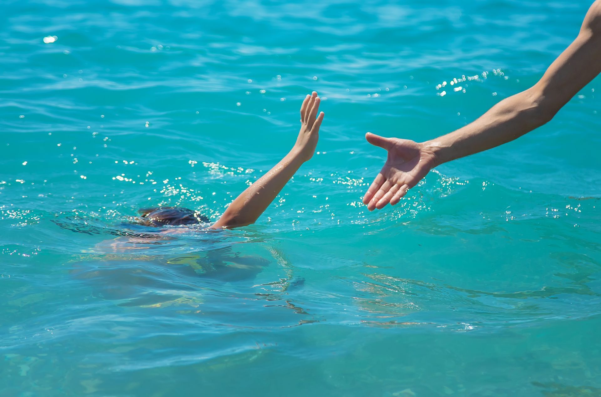The child is drowning in the water the hand of salvation