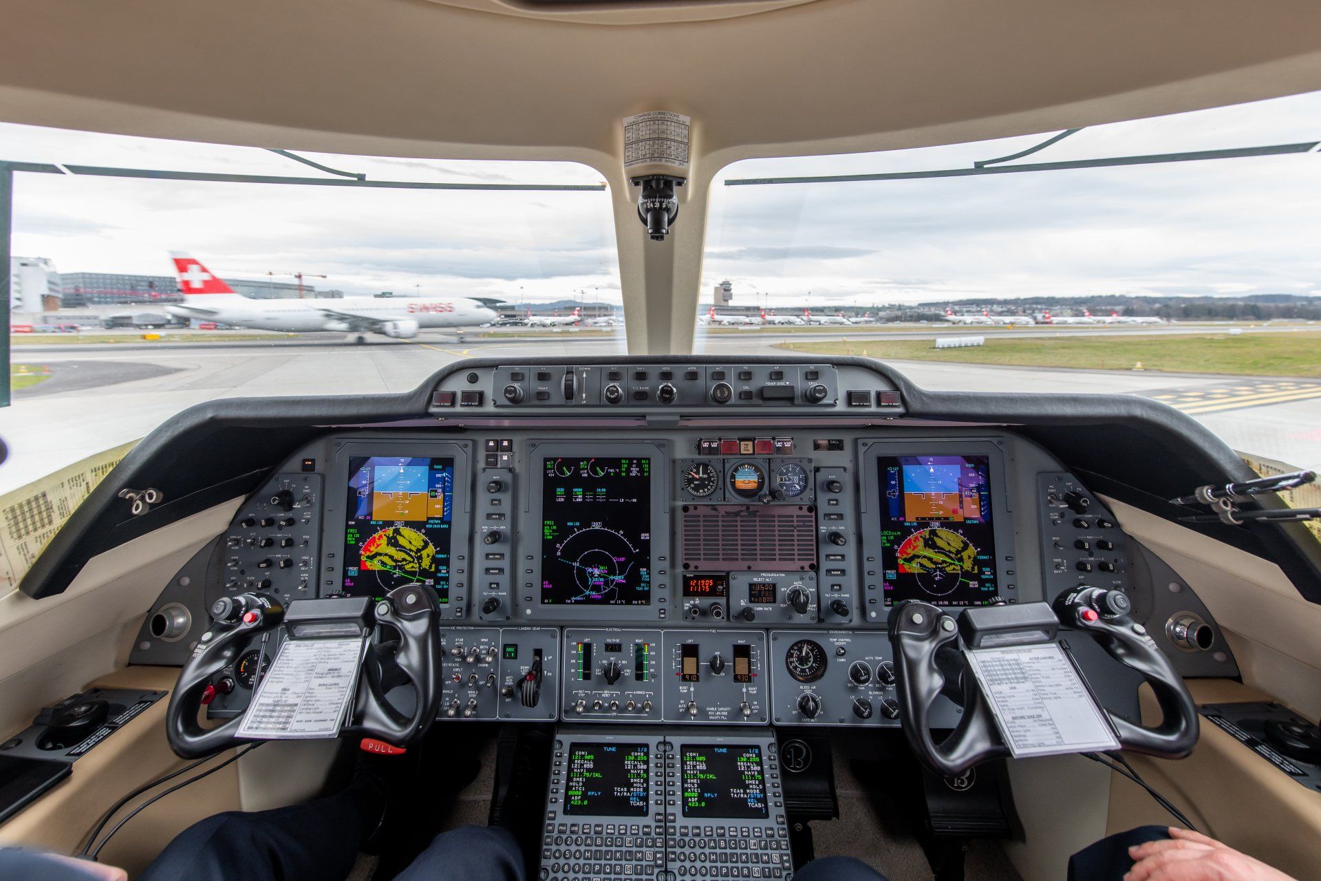 Cockpit view of a small passenger plane on the runway, with illuminated flight instruments and controls.