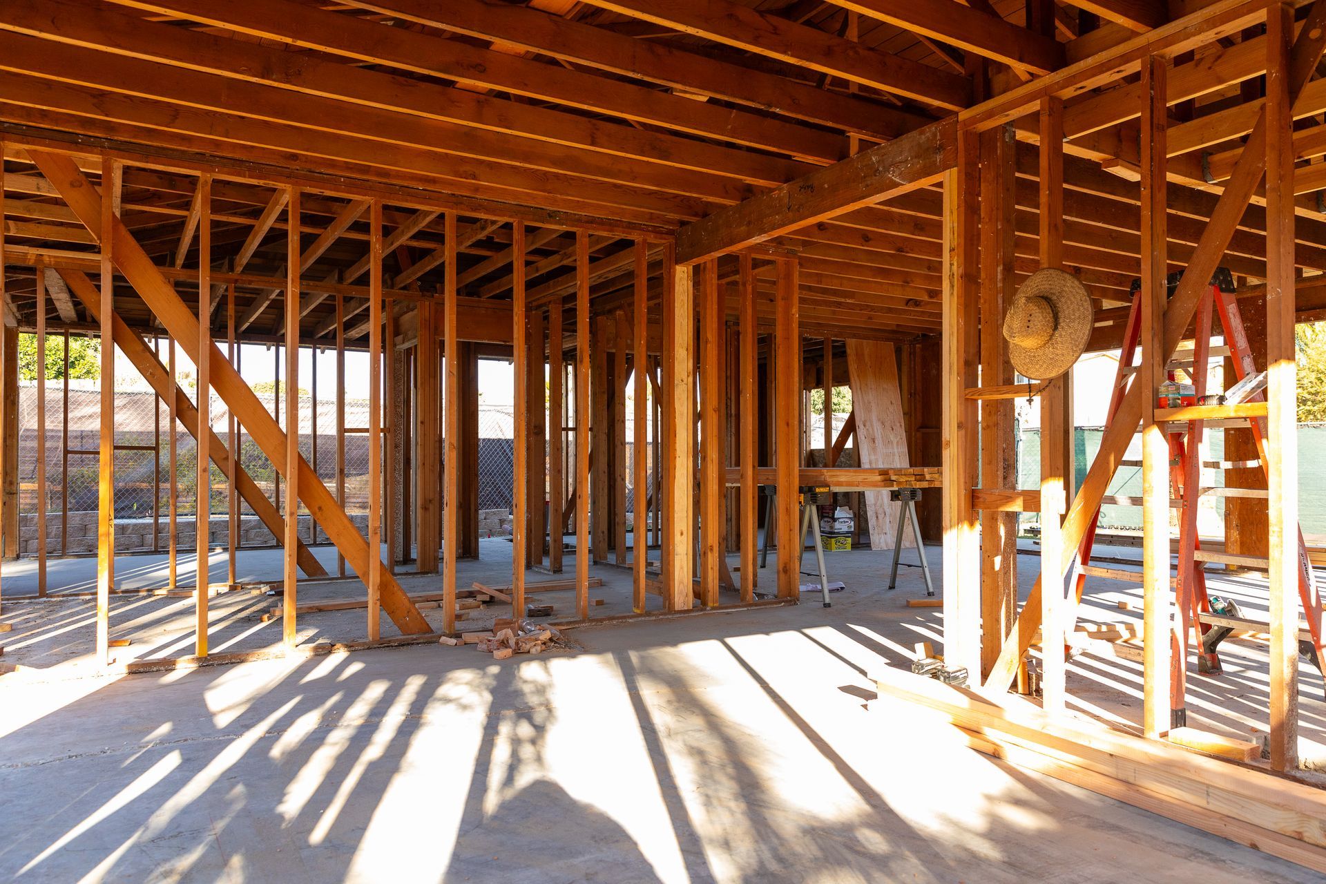 A house is being built with wooden beams and a ladder.