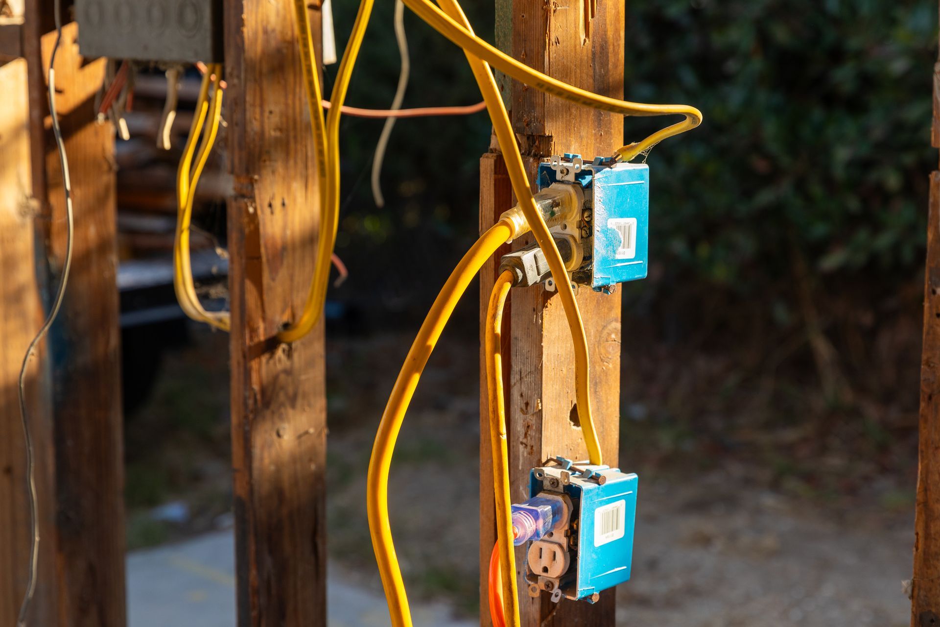 A bunch of wires are connected to a wooden post.