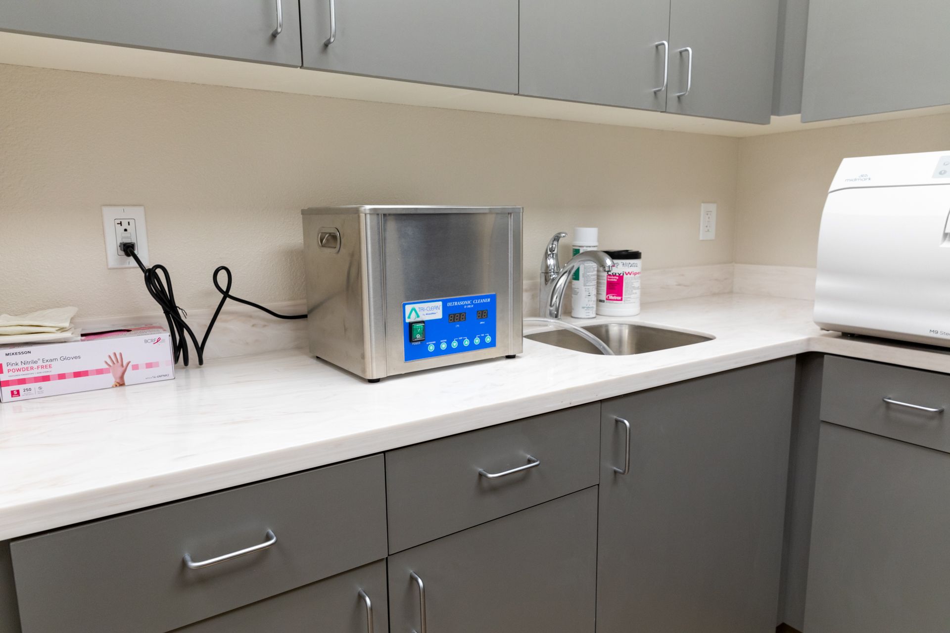 A kitchen with a sink and a microwave on the counter.