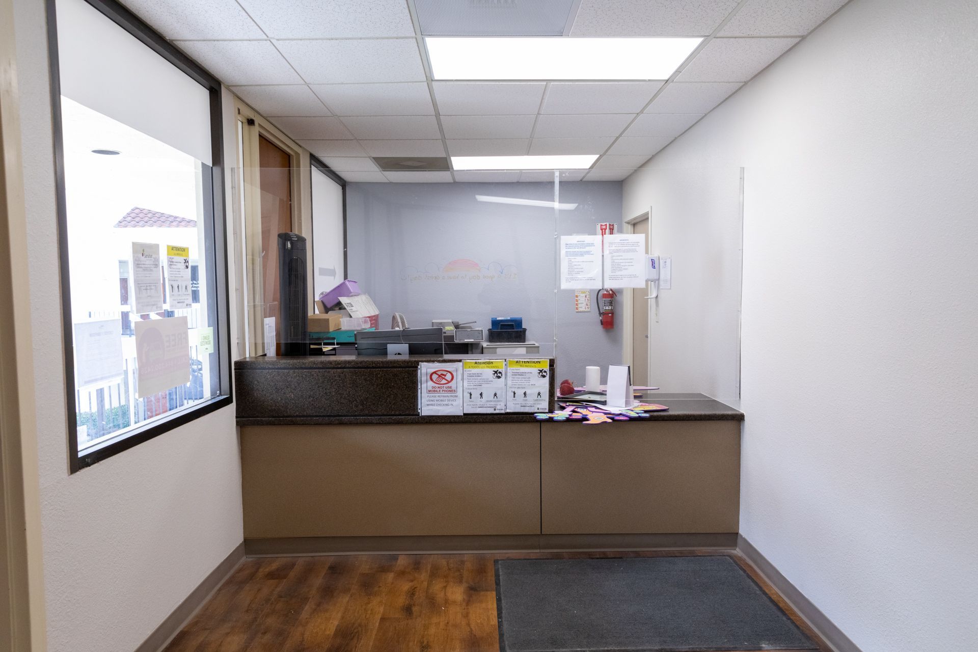 A reception area in a building with a counter and a window.