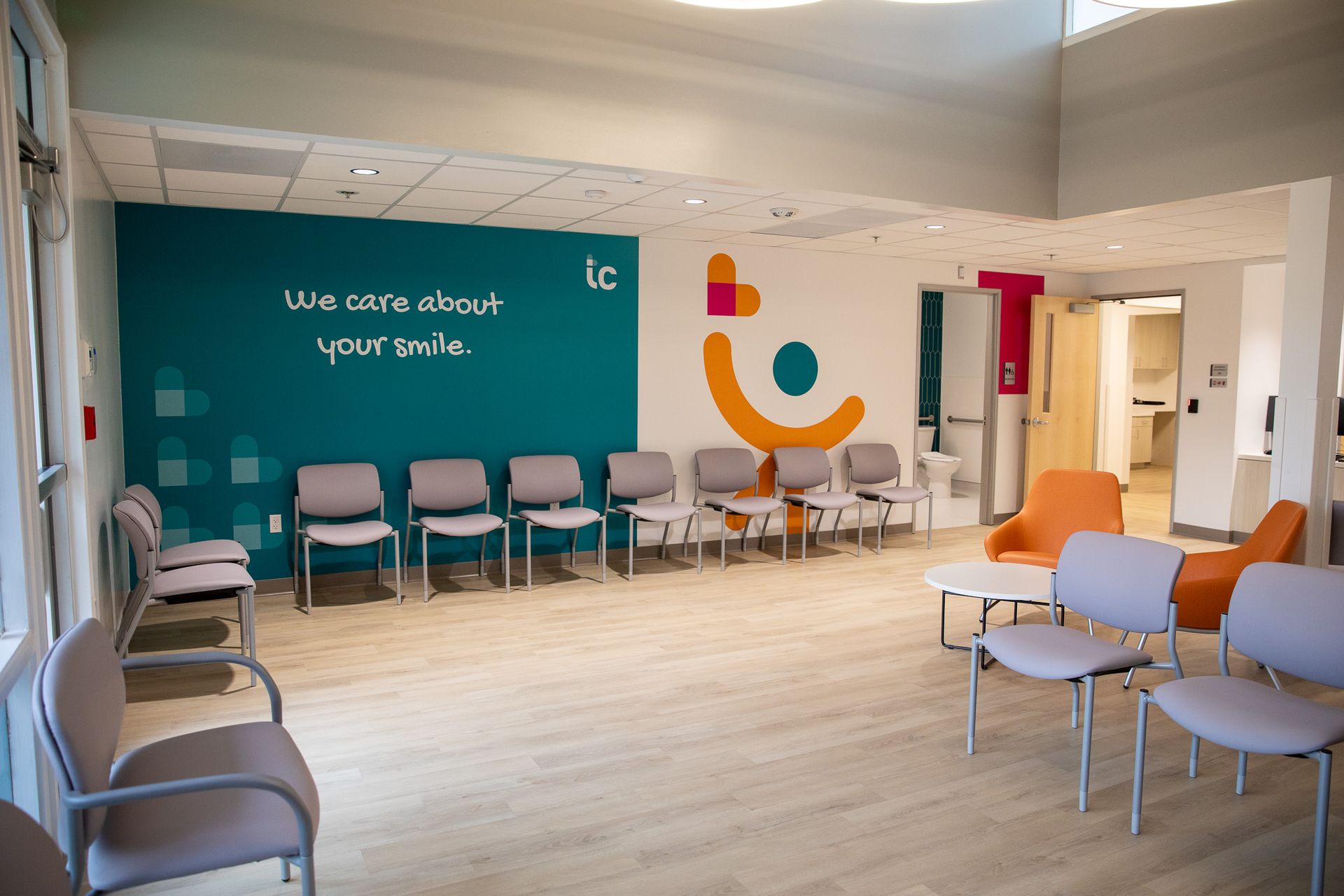 A waiting room with chairs and a wall that says we care about your smile
