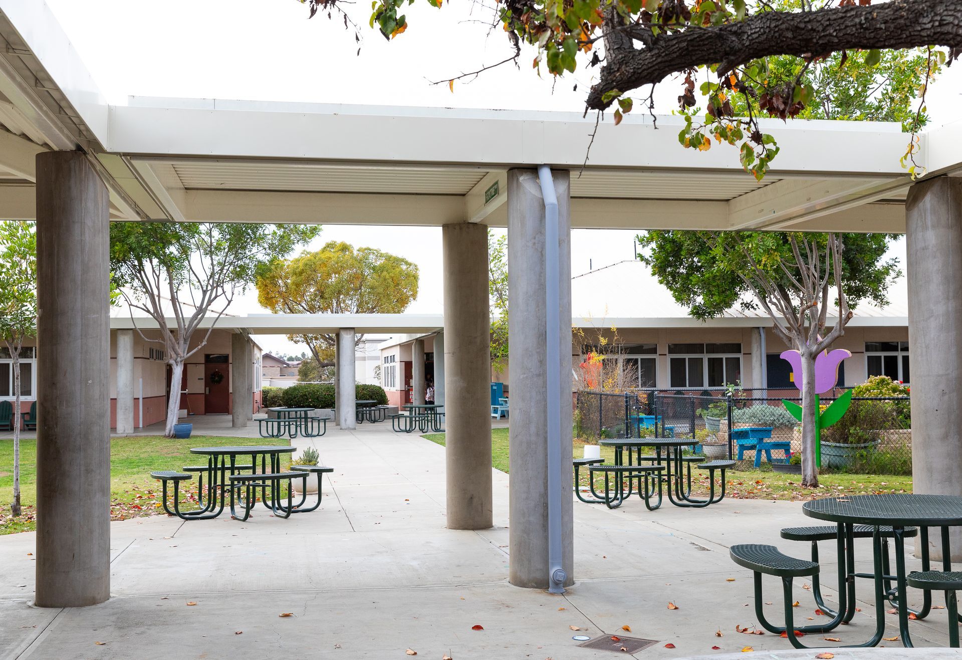 A picnic area with tables and chairs under a canopy