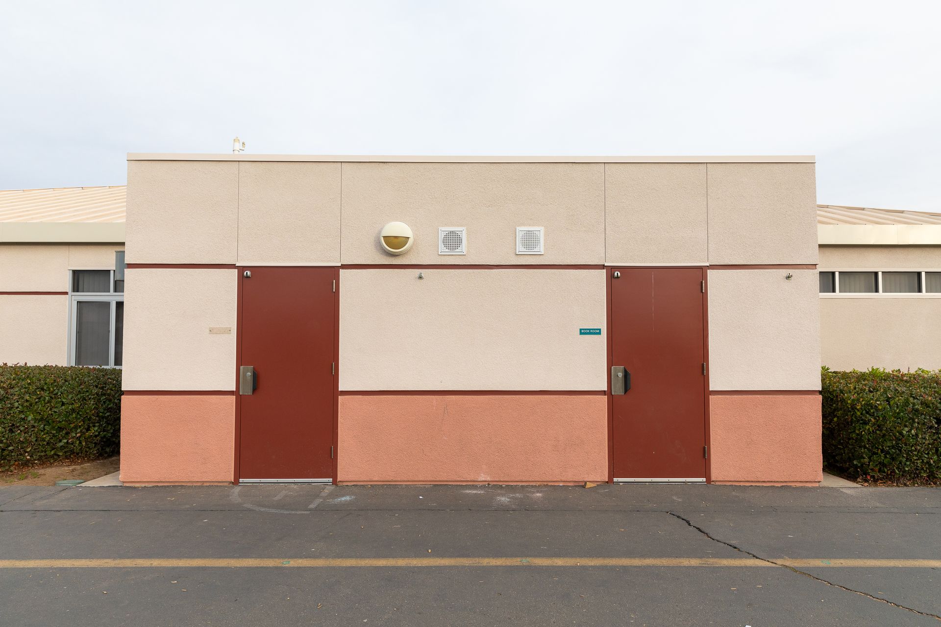 There are two red doors on the side of a building.