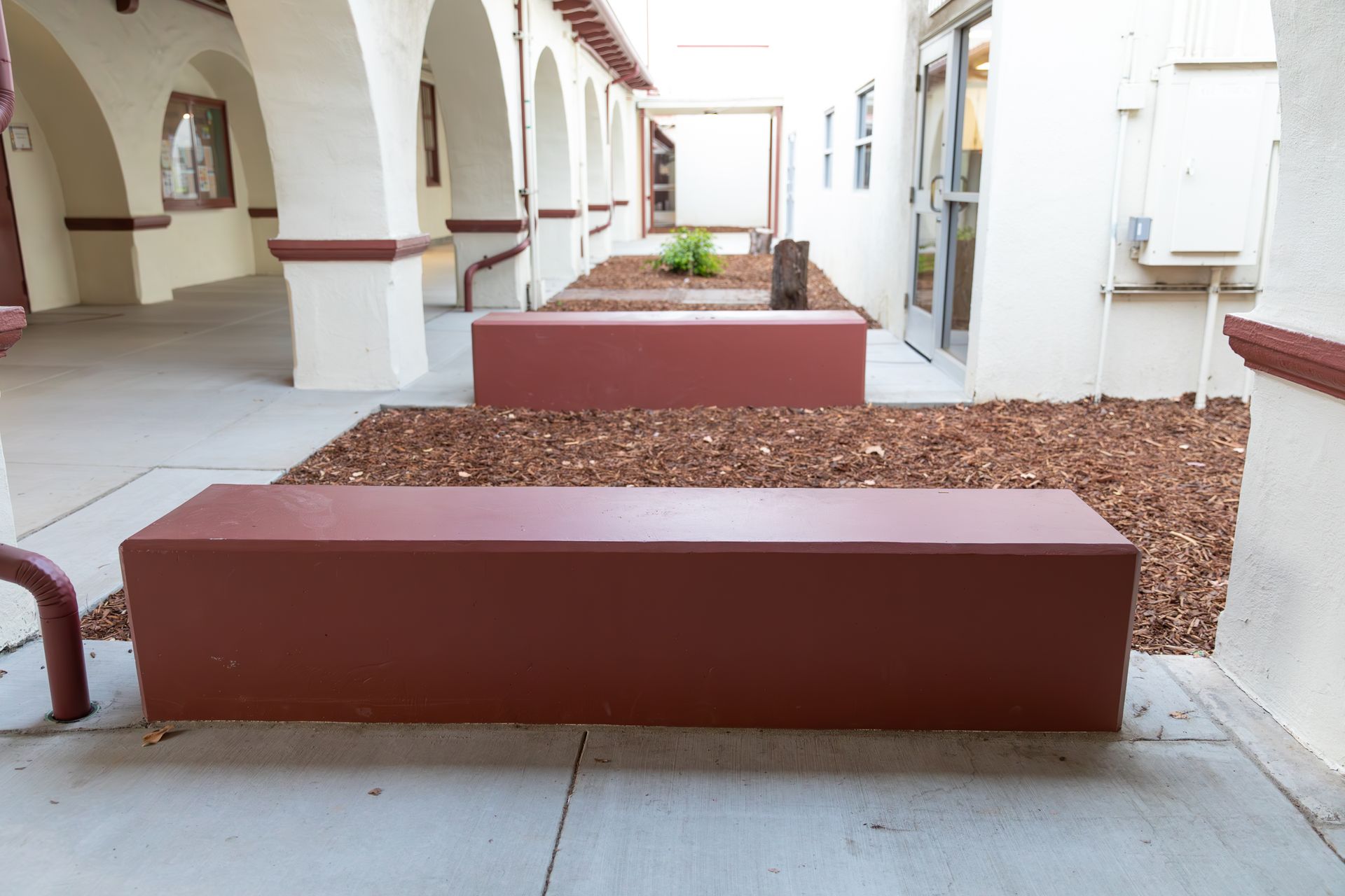 A red bench sits in the middle of a courtyard