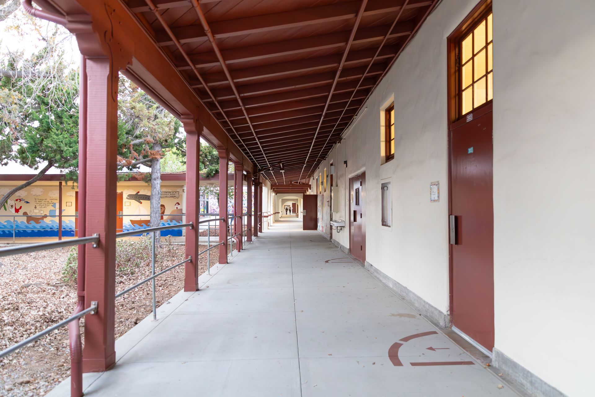 A long hallway with a covered walkway leading to a building