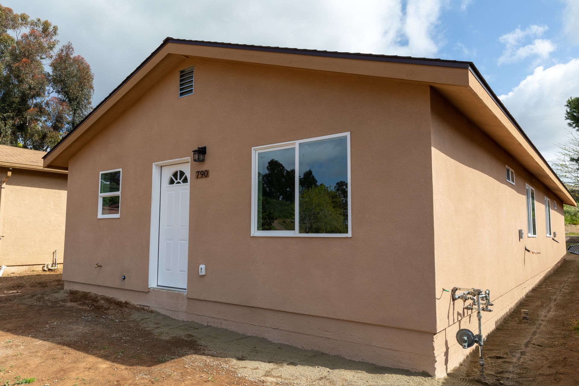 A small brown house with a white door and windows
