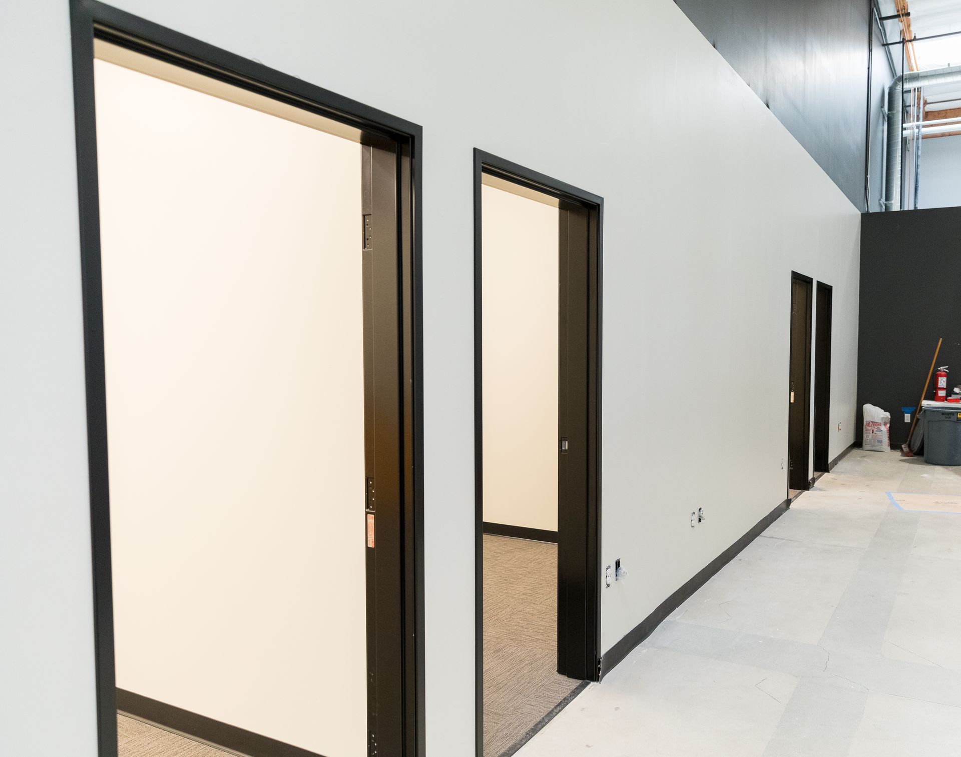 A hallway with a row of doors leading to different rooms in a building.