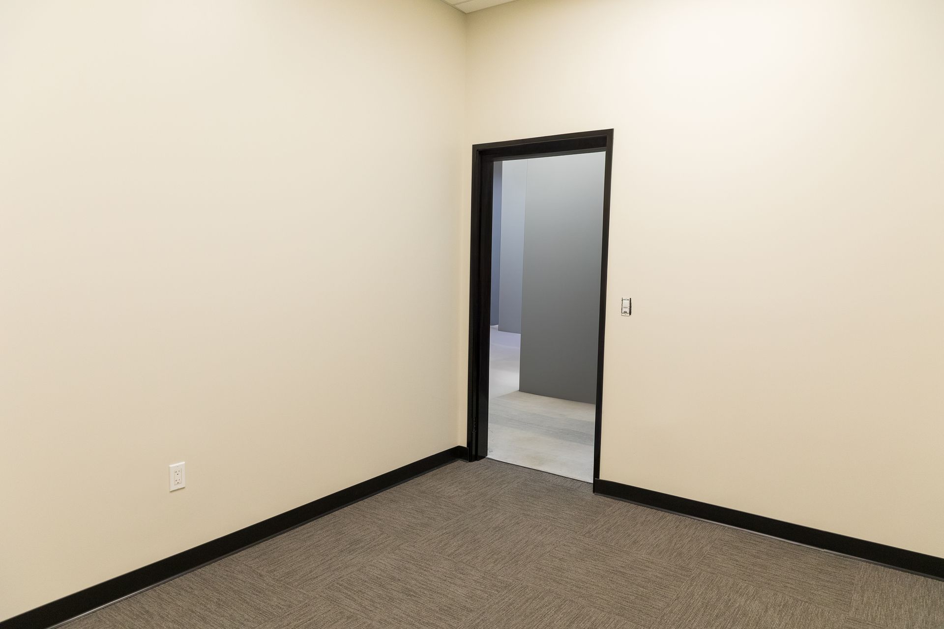 An empty room with a door that leads to another room.