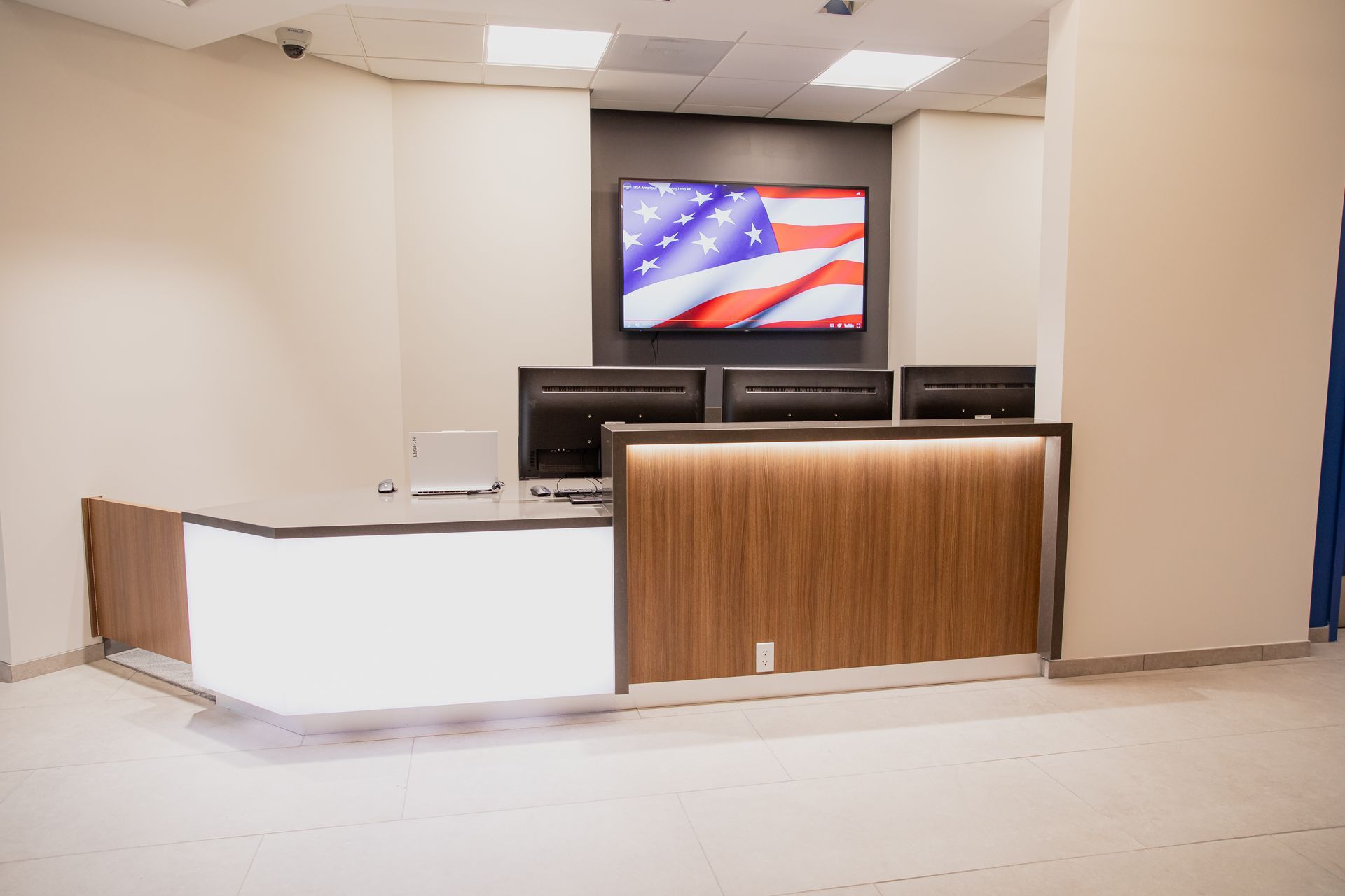 Empty reception desk in a room with a TV displaying the U.S. flag above it