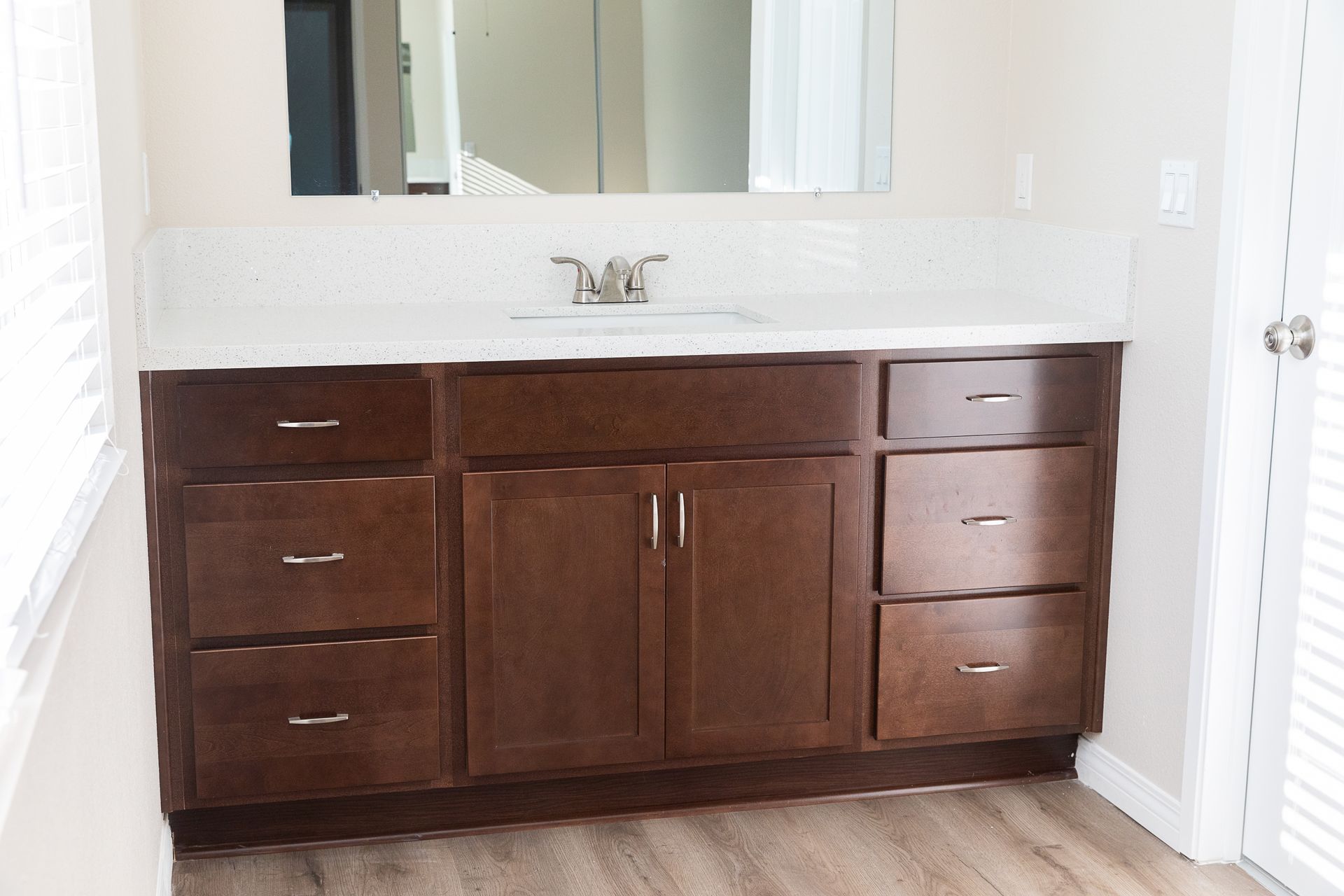 Dark wood bathroom vanity with double sink and wall mirror in a white room