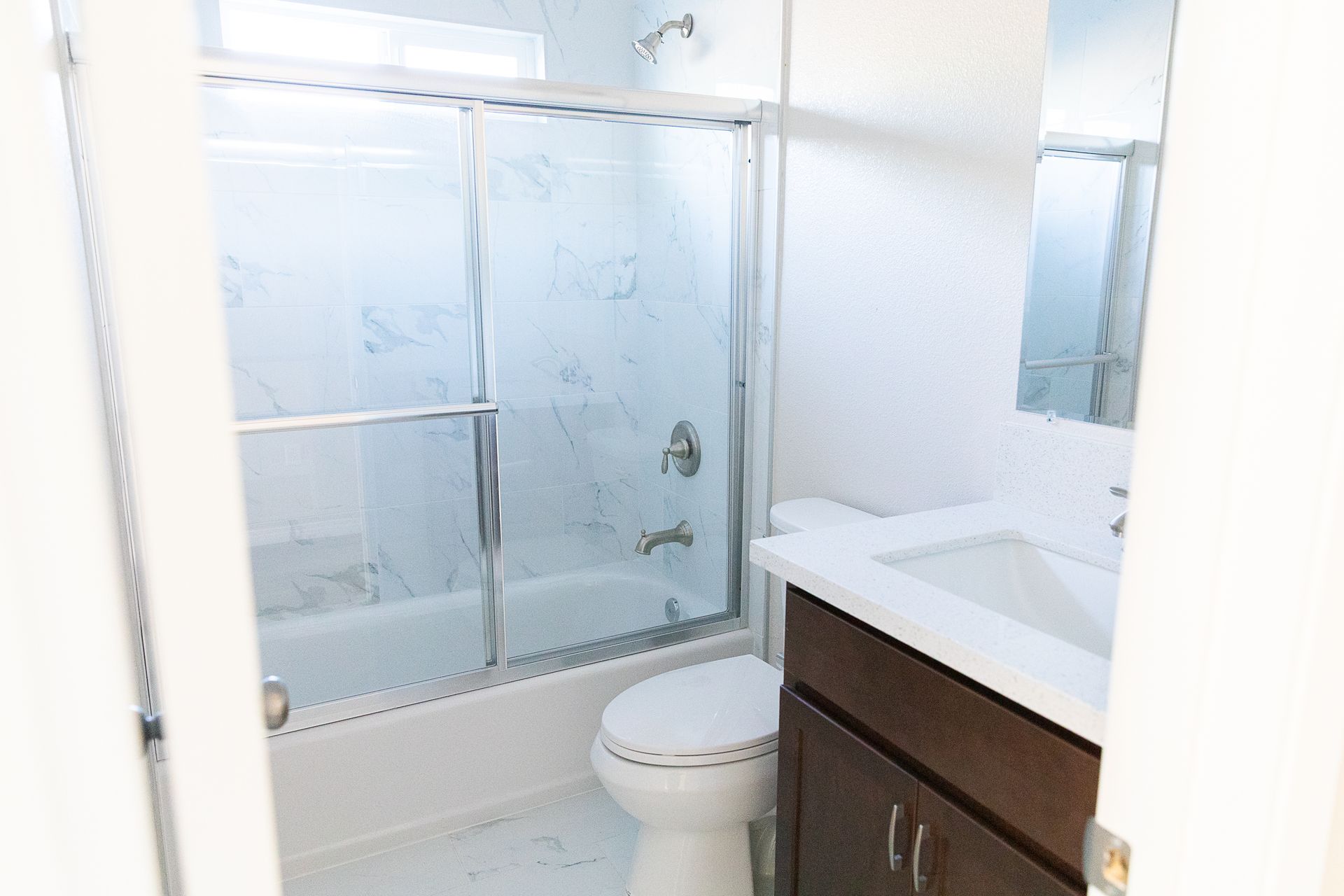 A bathroom with a toilet , sink , bathtub and shower.