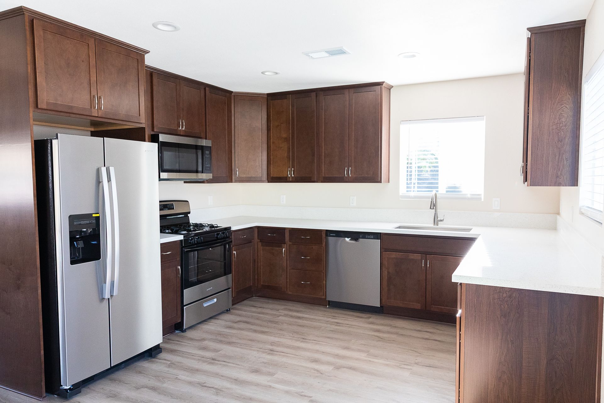 A kitchen with stainless steel appliances and wooden cabinets