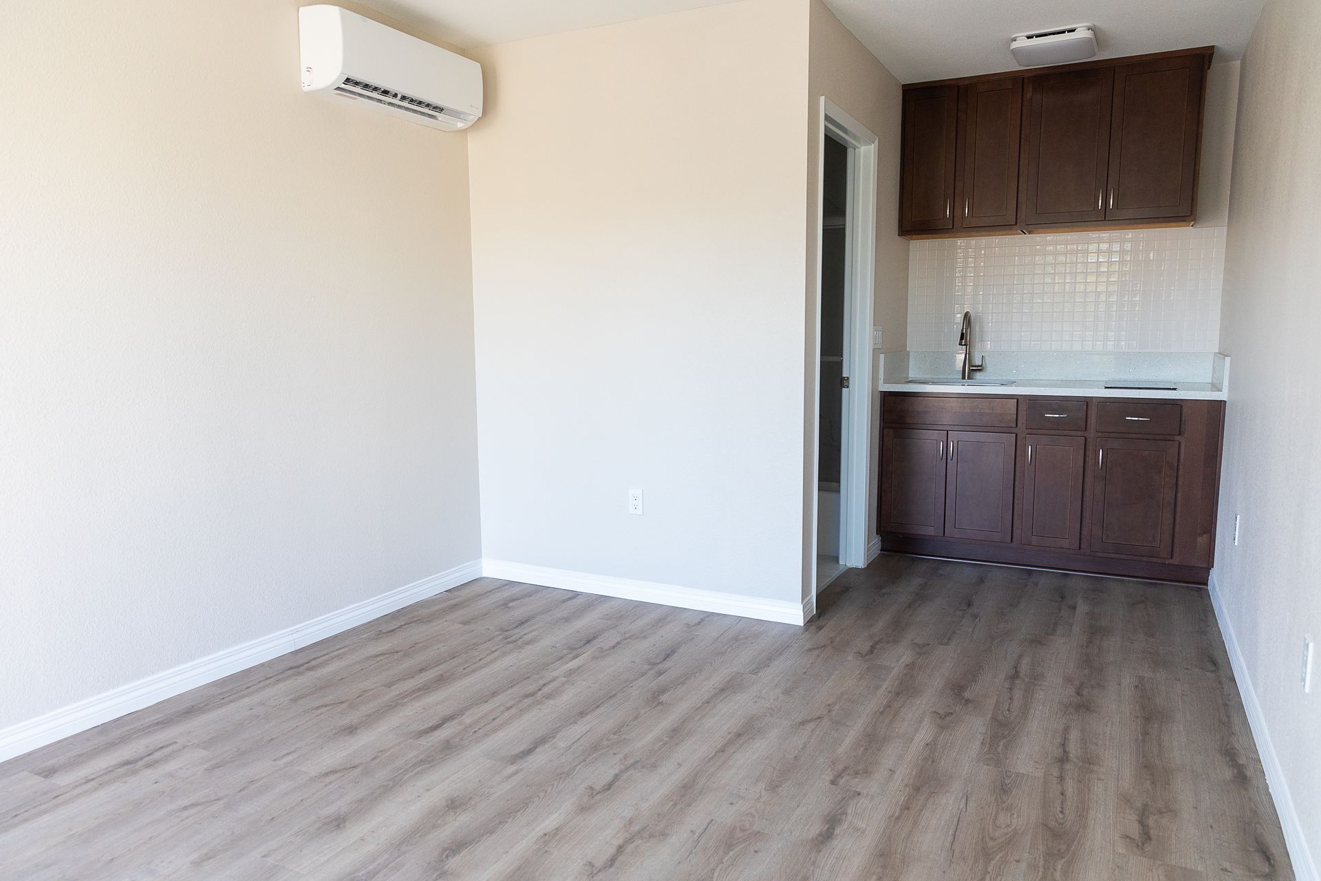There is a kitchen in the corner of the room.