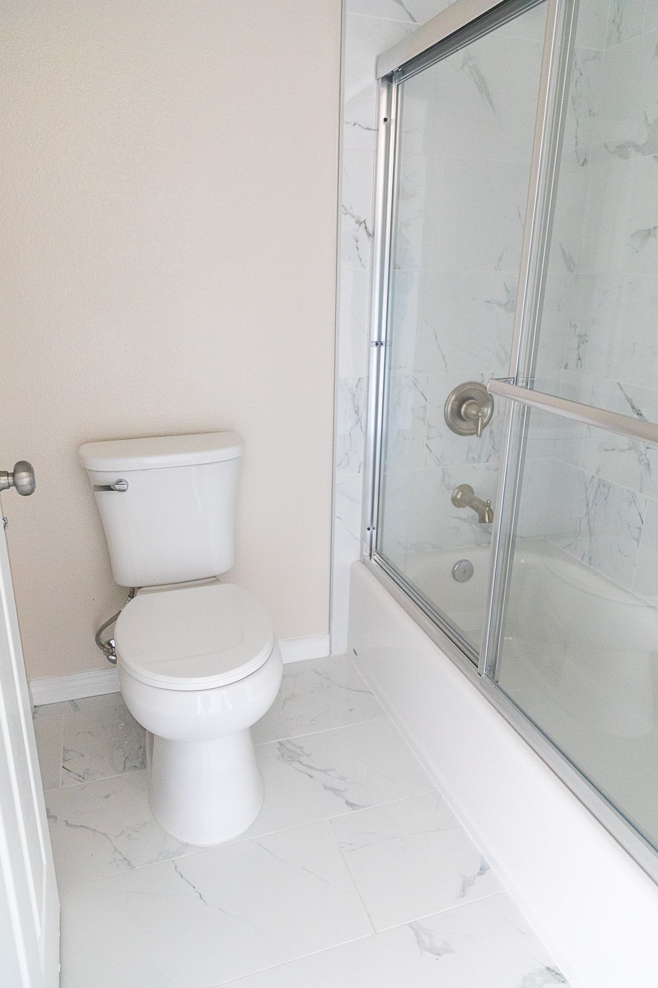 Small bathroom with a toilet and a glass shower stall beside it.