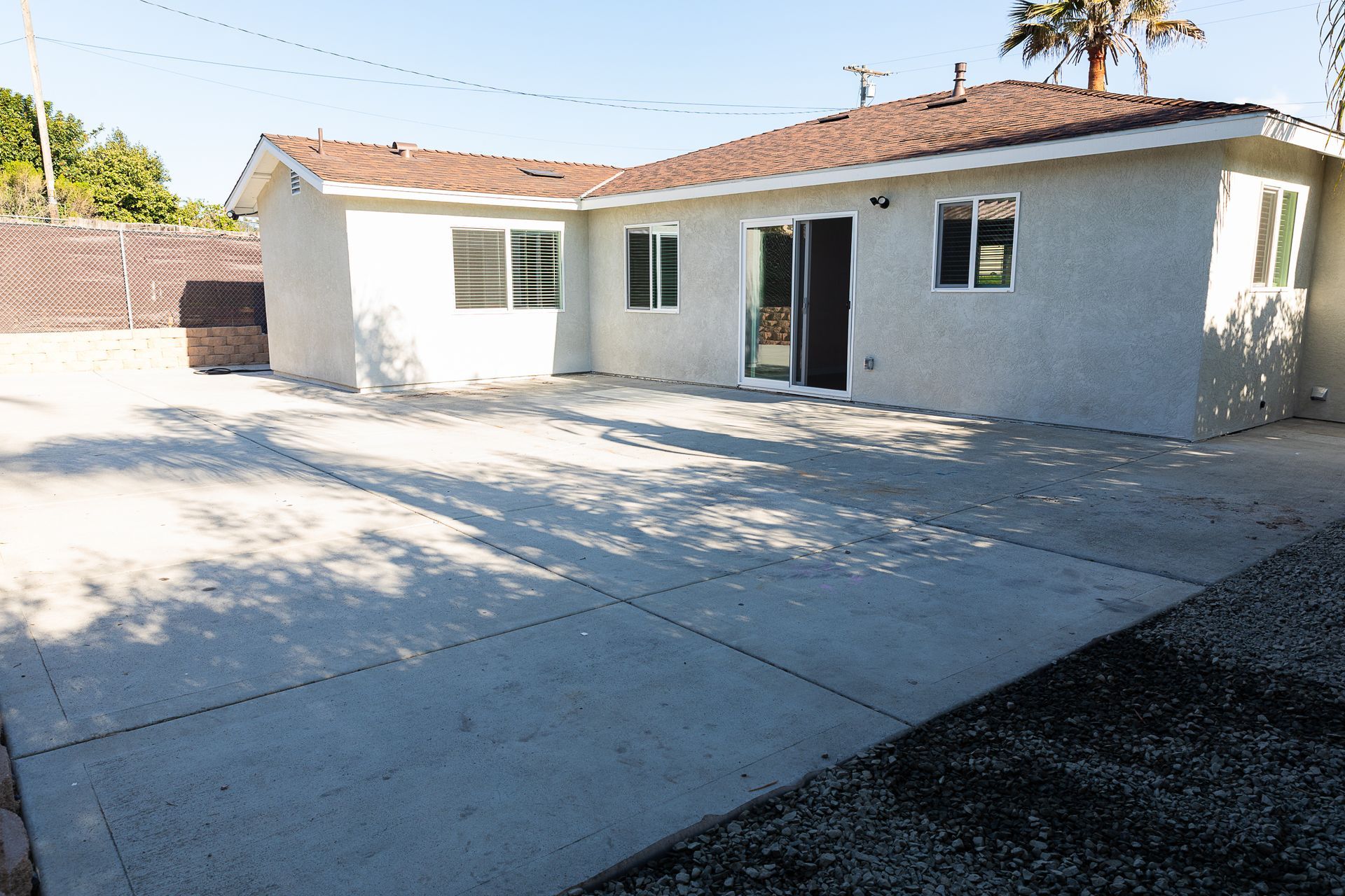 A white house with a concrete driveway in front of it