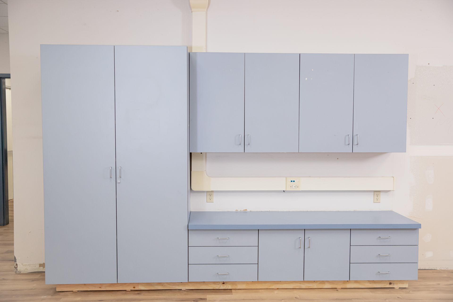 Light blue built-in cabinets and drawers against a white wall in a room