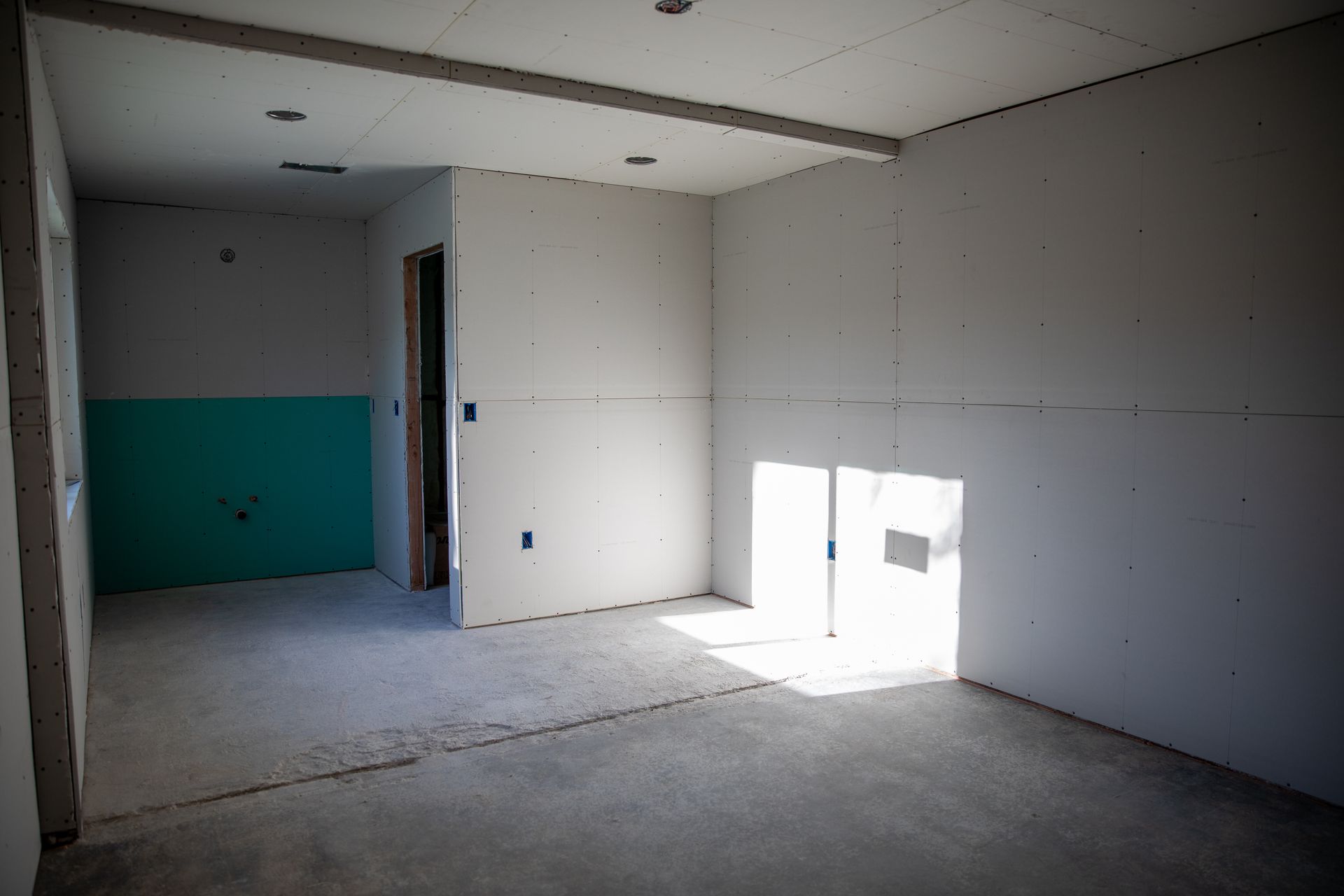An empty room with a green wall and white walls