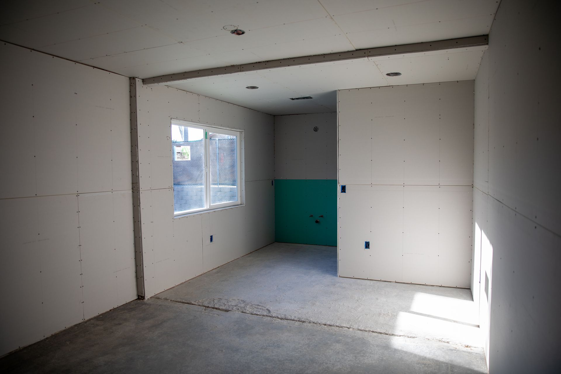 An empty room with white walls and a green wall