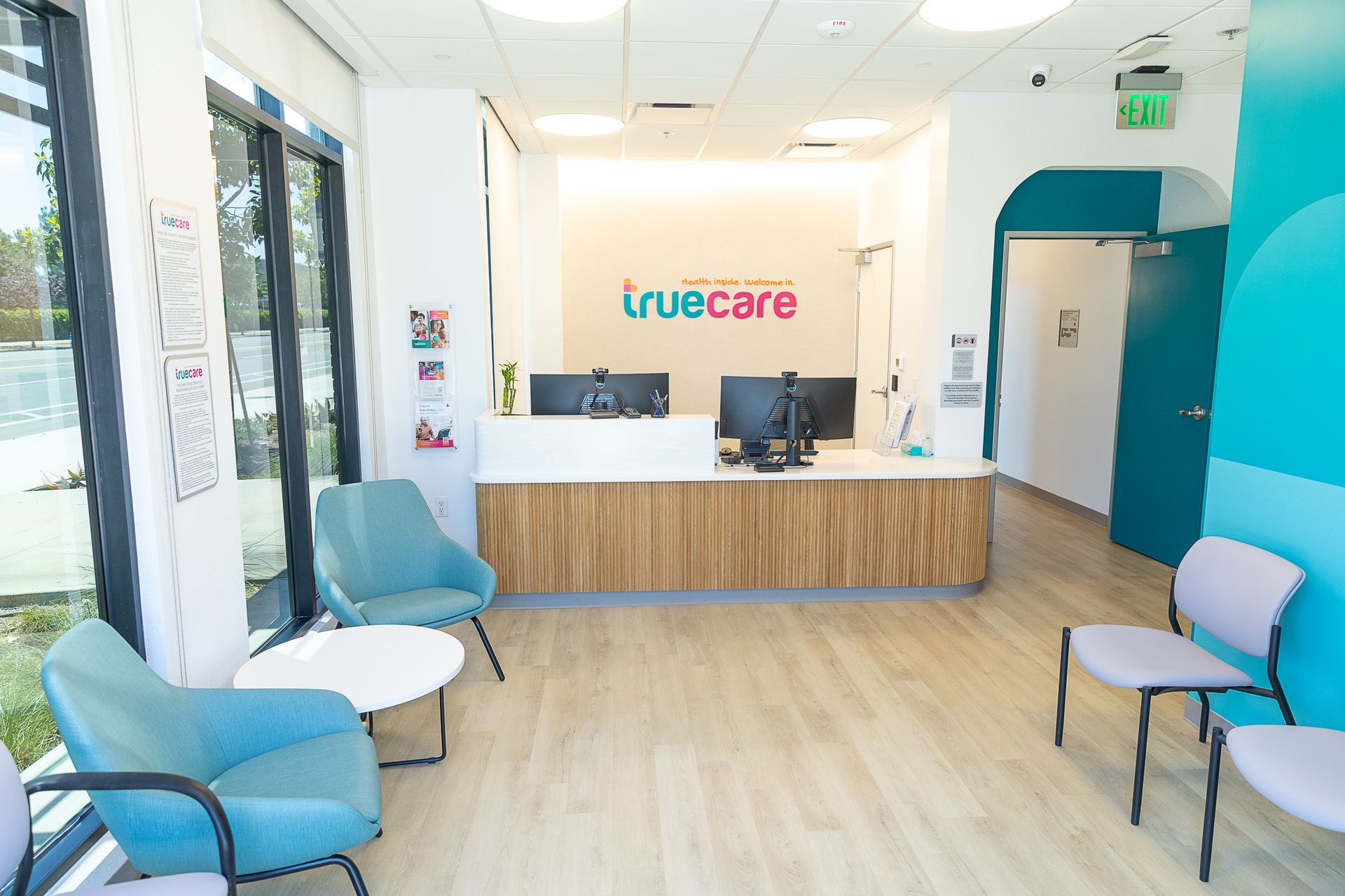 A waiting room with chairs , a table , and a counter.